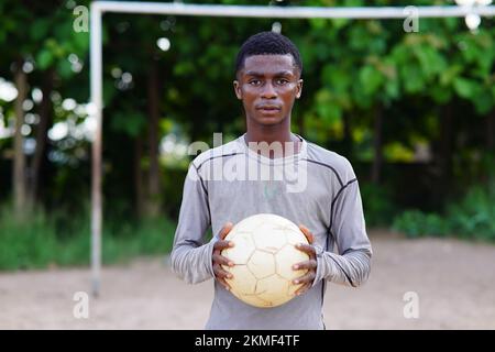 Un gros plan d'un adolescent africain tenant une balle Banque D'Images