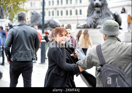 Londres, Royaume-Uni. 26th novembre 2022. Une femme en manteau noir avec son compagnon en veste de cuir prétendument soutenant la monarchie iranienne insulte les manifestants. La femme au pelage noir a frappé la blonde au visage et est arrêtée par la police. Les Iraniens protestent à Trafalgar Square. Manifestation à Londres au sujet de la mort de Mahsa Amini dans les mains de la police morale iranienne pour avoir mal porté son hijab. Credit: JOHNNY ARMSTEAD/Alamy Live News Banque D'Images