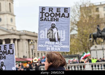 Trafalgar Square, Londres, Royaume-Uni. 26th novembre 2022 : proteste contre le gouvernement iranien et les manifestants de la coupe du monde du Qatar agitant des drapeaux et des bannières critiquant Téhéran, tout en tenant un ballon de football et un faux trophée de la coupe du monde taché de faux sang. Banque D'Images