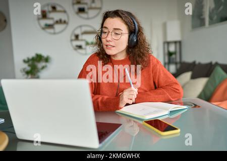 Jeune femme étudiant en ligne sur ordinateur portable à la maison. Banque D'Images