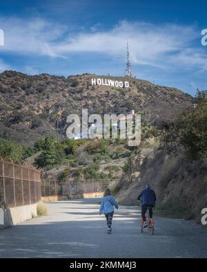 Los Angeles, CA, USA - November17, 2021: Un cycliste et un piéton voyagent sur la route d'incendie autour du lac Hollywood à Los Angeles, CA. Banque D'Images