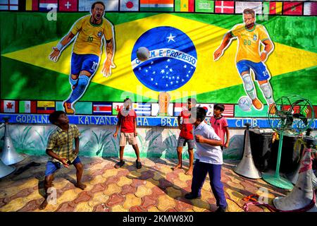 Kolkata, Inde. 26th novembre 2022. Les enfants ont vu jouer au football devant un mur de graffiti avec le drapeau brésilien et Neymar da Silva Santos Júnior, le long de la rue, alors qu'ils célèbrent la coupe du monde de la FIFA 2022 à Kolkata. Crédit : SOPA Images Limited/Alamy Live News Banque D'Images