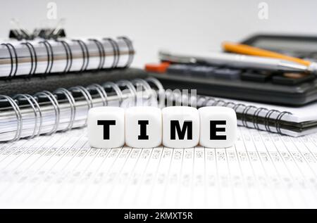 Concept commercial et financier. Sur la table, parmi les objets de bureau, des cubes avec l'inscription - TEMPS Banque D'Images