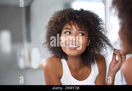 Avoir une bonne journée de cheveux. une jeune femme attirante prenant soin de ses cheveux. Banque D'Images