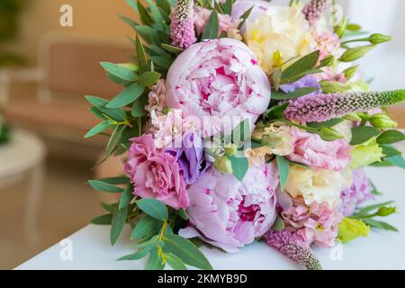 Bouquet riche de péonies roses et de fleurs lilas eustoma roses, feuille verte . Bouquet de printemps frais. Holodays, cadeau.Arrangement de belle floraison Banque D'Images