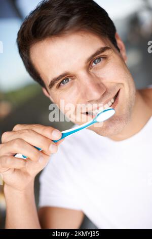 Pratiquer une bonne hygiène dentaire. Gros plan d'un jeune homme se brossant les dents. Banque D'Images