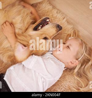 The best friend you can get. An adorable little girl with her dog at home. Stock Photo