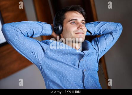 Liberté d'entreprise... Portrait d'un jeune homme d'affaires à l'écoute de la musique tout en prenant une pause. Banque D'Images