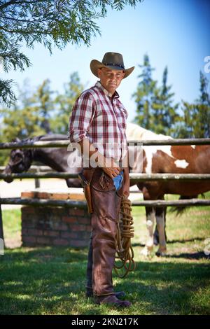 HES le wrangler des bêtes. Un cowboy mature à l'extérieur sur sa ferme. Banque D'Images