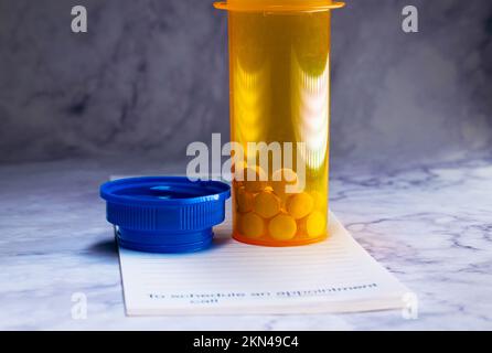 Ouvrez la bouteille de médicaments avec des pilules pour quelqu'un. au-dessus d'un bloc de prescription Banque D'Images