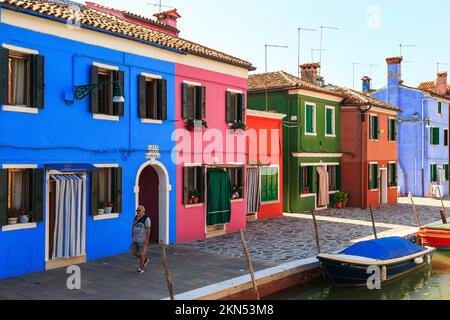 VENISE, ITALIE - 9 SEPTEMBRE 2018 : un homme non identifié marche le long de l'Embankment de Terranova, sur l'île de Burano, parmi des maisons colorées. Banque D'Images