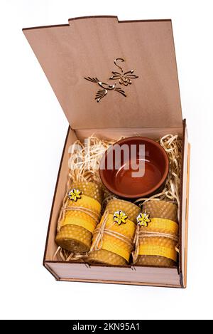 Vitamines et produits biologiques dans le cadeau. Miel dans un pot avec un bâton et des bougies de cire. Cadeau dans une boîte isolée sur blanc Banque D'Images