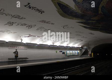 Une personne debout, attendant seule à une station de métro à Paris pour le train à venir - Cluny–la Sorbonne Banque D'Images