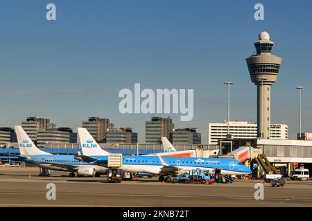 Amsterdam, pays-Bas - août 2022 : rangée de jets KLM garés dans l'un des bâtiments du terminal sous la tour de contrôle de la circulation aérienne à l'aéroport de Schipol Banque D'Images