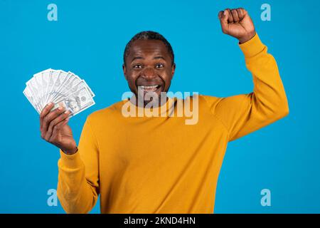 Homme américain africain émotionnel montrant de l'argent et des gestes Banque D'Images
