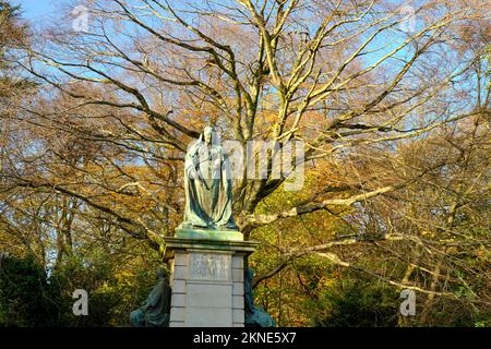 La statue de la reine Victoria dans le parc Endcliffe de Sheffield avec un décor d'automne de branches spectaculaires et de feuilles dorées. Banque D'Images