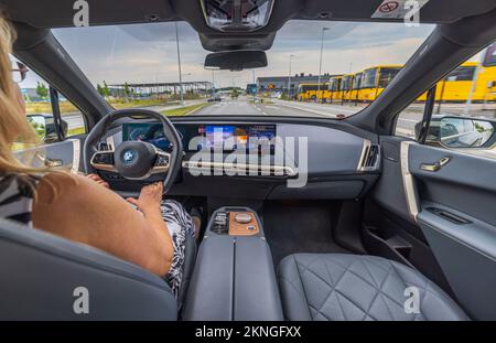 Vue rapprochée d'une femme conduisant une nouvelle voiture électrique BMW IX 40. Suède. Uppsala. Banque D'Images