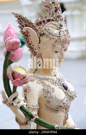 Une statue blanche perle de NAGA, une déesse mythique thaïlandaise tenant un bouquet de fleurs de lotus au Wat Pariwat Ratchasongkram. Un temple avec le bourgeon thaïlandais conte Banque D'Images