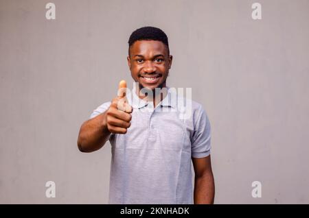 Un heureux, Afroamerican et beau homme riant et montrant le pouce vers le haut geste Banque D'Images