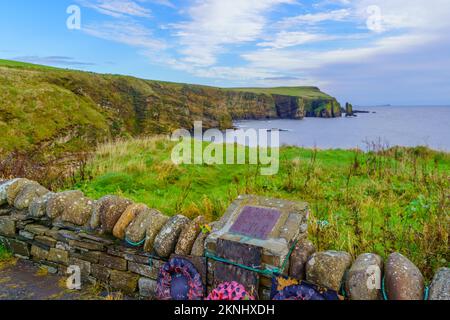 Windwick, Royaume-Uni - 05 octobre 2022 : vue sur les falaises le long de la côte, avec plaque commémorative, point de passage d'Ossi, et baie de Windwick. Île de South Ronalds Banque D'Images