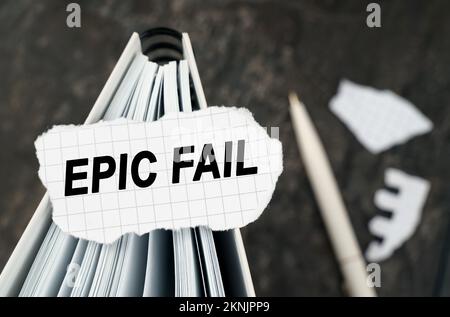 Sur la table se trouve un bloc-notes sur lequel repose un morceau de papier déchiré avec l'inscription - Epic Fail. Le stylet se trouve en dehors de la zone de netteté. Banque D'Images