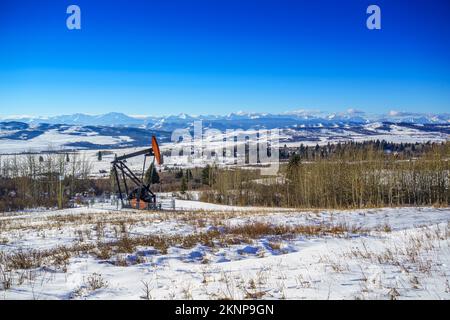 Un cric à pompe de puits d'huile en hiver dans les contreforts du sud de l'Alberta. Banque D'Images