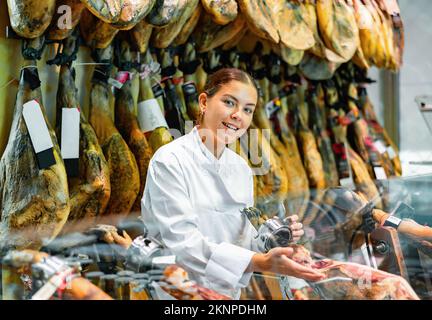 Femme joyeuse de jamoneria au comptoir Banque D'Images