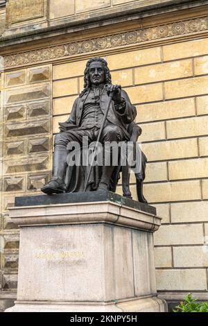 Copenhague, Danemark - 23 juillet 2022 : gros plan de la statue noire Ludvig Holberg sur un piédestal en pierre devant le Théâtre Royal, façade jaune Banque D'Images