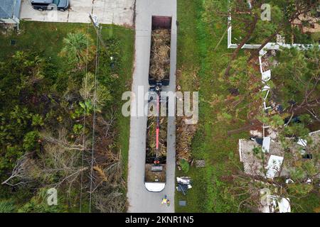 Vue aérienne de l'ouragan Ian après les secours camion-benne ramassant les débris de végétation des rues suburbaines de Floride. Traiter avec Banque D'Images