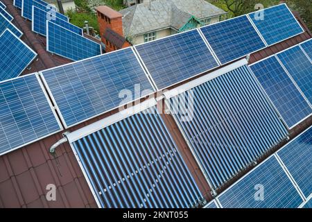 Panneaux photovoltaïques et capteurs solaires d'air à vide pour le chauffage de l'eau et la production d'électricité propre montés sur le toit de la maison. Production de Banque D'Images