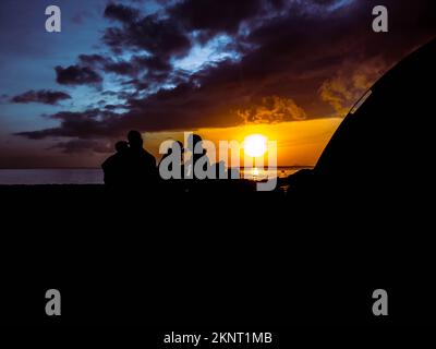 silhouette de personnes avec lever du soleil sur la plage Banque D'Images