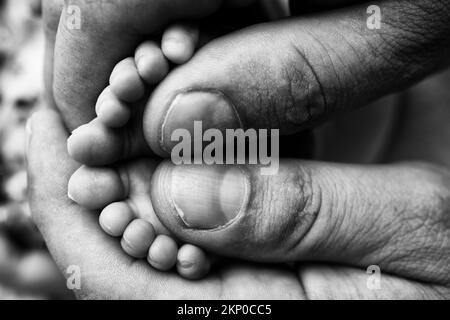 La mère fait un massage sur son pied de bébé. Gros plan des pieds de bébé dans les mains de la mère. Banque D'Images