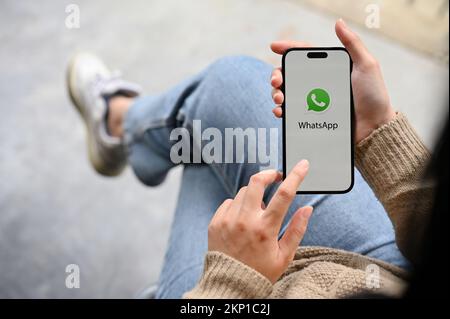 Chiang Mai, Thaïlande - novembre 25 2022 : une main féminine tenant un smartphone avec le logo de l'application WhatsApp à l'écran. vue de dessus Banque D'Images