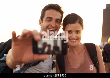 Prenons un autre... un jeune couple dans une ville étrangère prenant un selfie. Banque D'Images