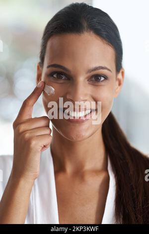 Gardez-le hydraté. Gros plan portrait d'une jeune femme magnifique appliquant un hydratant sur sa peau. Banque D'Images