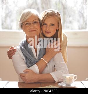 Liens familiaux. une jeune femme attirante qui visite son gran pour le thé. Banque D'Images