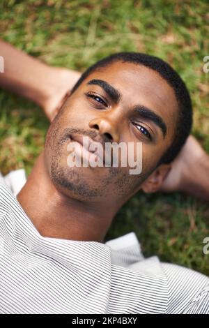 Prendre le soleil. un beau jeune homme couché sur l'herbe à l'extérieur. Banque D'Images