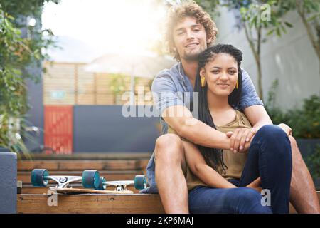 Le plus heureux quand theyre ensemble. un jeune couple assis ensemble à l'extérieur. Banque D'Images