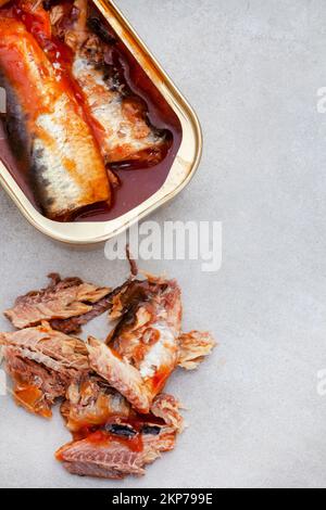 Sardines en conserve avec tomate sur une surface grise avec espace de copie Banque D'Images