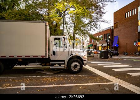 Cabine de jour compacte, grand camion semi-remorque blanc avec remorque à caisse pour les livraisons locales et les petites entreprises debout au carrefour le soir, petite ville Banque D'Images