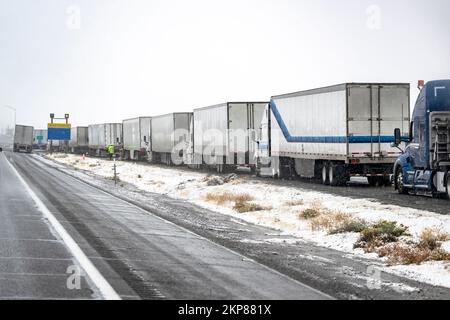 Convoi de gros engins de manutention semi-remorques avec semi-remorques transportant des marchandises commerciales sur une route glissante pendant un hiver sno Banque D'Images