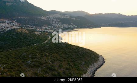 Magnifique paysage marin avec montagnes et ciel de coucher de soleil orange. Panorama de la station balnéaire en soirée. Paysage naturel pittoresque. Banque D'Images