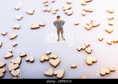 Coeurs en bois autour d'un homme figurine sur fond blanc Banque D'Images