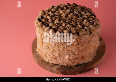 photo de gâteau rond de noyer sur une planche en bois vue latérale sur fond rose vue latérale Banque D'Images