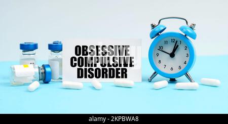 Médecine et concept de santé. Un réveil, des pilules, des injections et une carte avec l'inscription - trouble obsessionnel-compulsif Banque D'Images