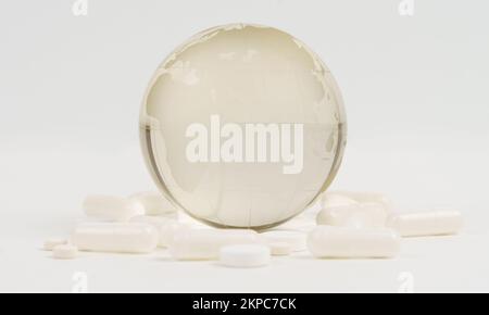 Maladies et traitements mondiaux. Les pilules et les capsules se trouvent près du globe de verre de la planète Terre. Sauver la planète du virus. Banque D'Images