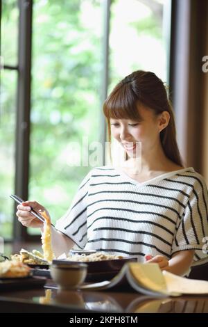 Femme japonaise mangeant tempura soba Banque D'Images