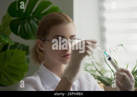 Médecin ou scientifique dans un hôpital de laboratoire avec seringue d'injection en main. Gros plan, mise au point sélective. Banque D'Images