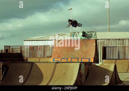 bmx biker faisant un plateau de table dans une rampe Banque D'Images