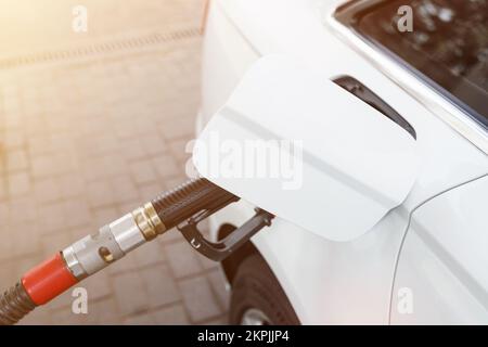 Concept transport et industrie. Remplissage de la voiture. Une vanne de ravitaillement est insérée dans le goulot de remplissage de carburant. Banque D'Images